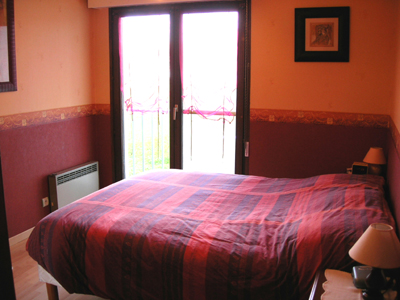 Chambre spacieuse donnant sur l'arrire de la coproprit - revtement parquet.